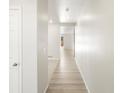 Bright hallway with light hardwood floors leading to rooms in the house at 6068 Corral St, Brighton, CO 80601