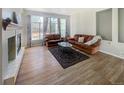 Bright living room featuring hardwood floors, a fireplace, and large windows at 9806 Hooker Ct, Denver, CO 80031