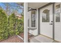 Close-up of a stylish front door with decorative glass, accompanied by lush greenery and a bay window at 4350 S Delaware St, Englewood, CO 80110