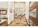 Grand foyer with high ceilings, tile flooring, staircase, and views into living spaces at 2253 Augusta Dr, Evergreen, CO 80439