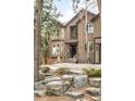 Charming two-story home with a cozy front porch and stone landscaping, nestled amongst mature trees for added privacy at 2253 Augusta Dr, Evergreen, CO 80439