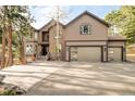 Charming two-story home with a three car garage and large driveway surrounded by mature trees at 2253 Augusta Dr, Evergreen, CO 80439
