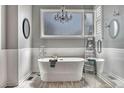 Elegant bathroom with a freestanding tub, a chandelier, wainscoting, and a glass-enclosed shower at 570 Stonemont Dr, Castle Pines, CO 80108