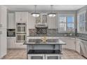 Modern kitchen with white cabinets, stainless steel appliances, granite counters, and a central island with seating at 570 Stonemont Dr, Castle Pines, CO 80108