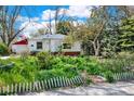 Quaint home with a landscaped front yard featuring lush greenery and a cozy detached garage at 5211 Dover St, Arvada, CO 80002