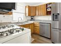 Bright kitchen featuring stainless steel appliances, countertop and wooden cabinets at 5211 Dover St, Arvada, CO 80002