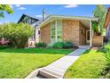 Charming brick home with a well-manicured lawn and colorful flowers enhancing the curb appeal at 1622 Monroe St, Denver, CO 80206