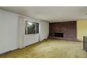 Bright living room featuring a brick fireplace, large window with curtains and cozy carpet at 1720 S Balsam St, Lakewood, CO 80232