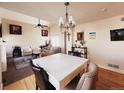 Bright dining and living area with wood floors, chandelier and a ceiling fan at 9889 Aftonwood St, Highlands Ranch, CO 80126