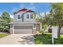 Charming two-story home with gray siding, a two-car garage, landscaped yard, and inviting front porch at 9889 Aftonwood St, Highlands Ranch, CO 80126