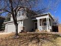Inviting home showcasing a two-car garage and welcoming front porch with white railings at 9889 Aftonwood St, Highlands Ranch, CO 80126