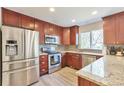 Beautiful kitchen featuring stainless steel appliances, cherry cabinets, gray backsplash, and granite countertops at 9889 Aftonwood St, Highlands Ranch, CO 80126