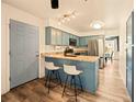 Bright kitchen featuring a breakfast bar, stainless steel appliances, and stylish blue cabinetry at 12234 W Saratoga Ave, Morrison, CO 80465