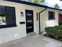 Close up of a modern front door on a painted brick home with updated fixtures at 2836 S Fenton St, Denver, CO 80227