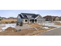 Two-story home with gray siding, stone accents, and a three car garage at 528 Nesting Eagles Way, Berthoud, CO 80513