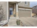A close up of the front entryway and attached two-car garage of this charming home at 5572 Fullerton Cir, Highlands Ranch, CO 80130