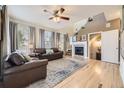 Spacious living room with a fireplace, large windows, and hardwood floors at 5572 Fullerton Cir, Highlands Ranch, CO 80130