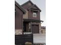 Brown-sided two story home with stone accents and attached garage at 15601 W Eureka Ave, Morrison, CO 80465