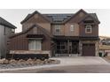 Two-story home with brown siding, stone accents, and solar panels at 15601 W Eureka Ave, Morrison, CO 80465