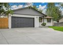 Charming single-story home featuring a large driveway, two-car garage, and inviting lawn at 8357 Dudley Ct, Arvada, CO 80005