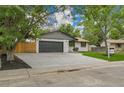 Charming single-story home featuring a large driveway, two-car garage, and inviting lawn at 8357 Dudley Ct, Arvada, CO 80005