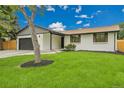 Charming single-story home featuring a large driveway, two-car garage, and inviting lawn at 8357 Dudley Ct, Arvada, CO 80005