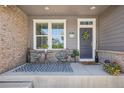 A charming front porch decorated with stylish furniture, a patterned rug, and a welcoming floral wreath on the door at 8677 S Buchanan Way, Aurora, CO 80016