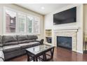 Comfortable living room features a stone fireplace, large windows, and a dark leather couch at 6765 S Old Hammer Ct, Aurora, CO 80016
