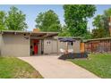 Exterior showcasing a driveway leading to the home with a bright red front door and landscaped front yard at 1831 S Ivanhoe St, Denver, CO 80224