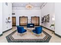 Elegant lobby with chandelier, plush seating, marble floors, and gold elevator doors at 444 17Th St # 1003, Denver, CO 80202