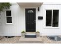 Charming front entrance with a modern black door, decorative window, and inviting landscaping at 3073 W Center Ave # C, Denver, CO 80219
