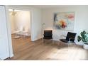Bright living room with hardwood floors, stylish artwork, and a view into the dining area at 3073 W Center Ave # C, Denver, CO 80219