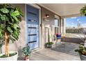 Inviting front porch featuring a blue door, decorative plants, and comfortable seating, creating a welcoming entrance at 1194 S Washington St, Denver, CO 80210