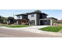 Modern two-story home featuring a gray brick facade, dark garage door, and well-manicured lawn at 5358 Lions Paw St, Castle Rock, CO 80104