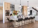 Bright kitchen featuring natural wood cabinets, a large island with bar seating, and a wine fridge at 5358 Lions Paw St, Castle Rock, CO 80104