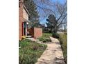 Well-maintained front yard with a sidewalk, brick fence, garden bed, and view of the surrounding neighborhood at 11886 Elk Head Range Rd, Littleton, CO 80127