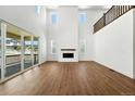 Spacious living room with tall ceilings, large windows, fireplace, and hardwood floors at 5629 Farrier Pt, Castle Rock, CO 80104