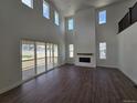 Bright and airy living room boasts soaring ceilings, a fireplace, and access to the outdoor patio at 5629 Farrier Pt, Castle Rock, CO 80104