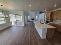 Open-concept living space with a modern kitchen island, high ceilings, and seamless flow to outdoor patio at 5629 Farrier Pt, Castle Rock, CO 80104