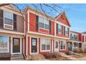 Charming red townhome with black shutters, landscaping, and a welcoming entrance at 1011 Milo Cir # A, Lafayette, CO 80026