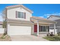 Charming two-story house with a red door, an attached garage, and landscaped front yard on a clear day at 19153 E 51St Ave, Denver, CO 80249