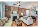 Cozy living room featuring exposed brick, a fireplace, and hardwood floors at 2530 N Franklin St, Denver, CO 80205