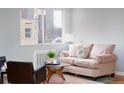 Cozy living room featuring a comfortable pink sofa, stylish decor, and a large window offering natural light at 1100 Colorado Blvd # 305, Denver, CO 80206