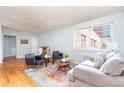 Bright living room with hardwood floors, comfortable seating, and a colorful area rug at 1100 Colorado Blvd # 305, Denver, CO 80206