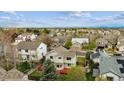 An aerial view of homes featuring green trees and spacious lawns on a sunny day at 5174 S Ukraine St, Aurora, CO 80015
