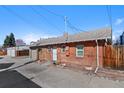 Exterior shot of brick house featuring an attached garage, a well manicured yard, and stonework at 3835 N Raleigh St, Denver, CO 80212