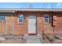 A classic red brick home is showcased, featuring a charming front door and meticulously kept landscaping at 3835 N Raleigh St, Denver, CO 80212