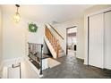 Inviting foyer features stone floors, coat closet, and staircase to the second floor at 25728 Stanley Park Rd, Evergreen, CO 80439