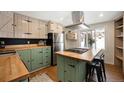 Bright and airy kitchen featuring butcher block island with gas cooktop and stainless steel appliances at 25728 Stanley Park Rd, Evergreen, CO 80439