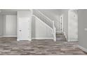 Open living space featuring wood flooring, a staircase and a white interior door at 8894 Yellowcress St, Littleton, CO 80125